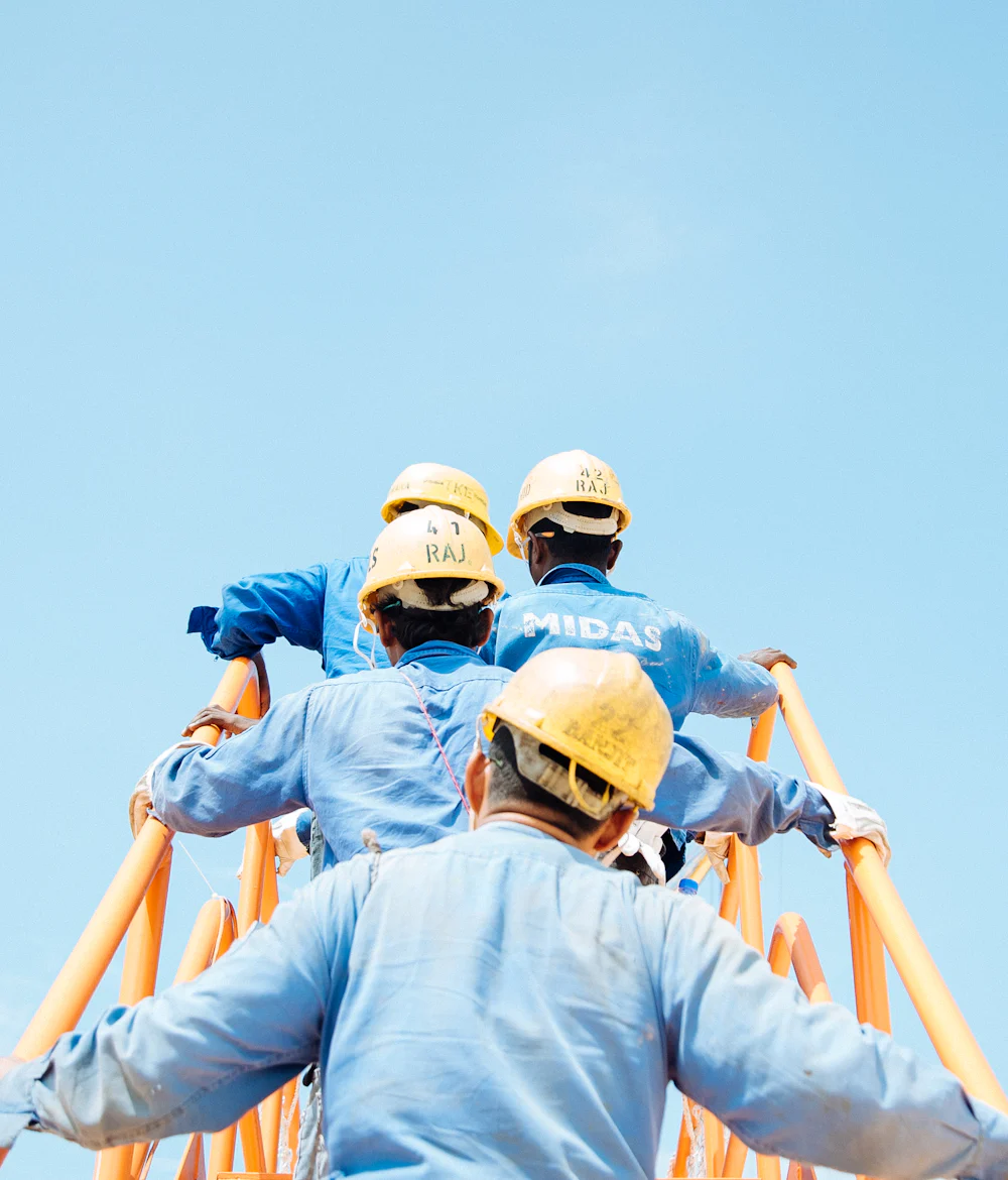 Cuadrilla de trabajadores con casco y equipo de protección personal en obra